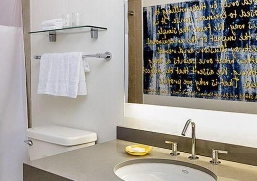 a bathroom with a sink and a toilet and a mirror at Lovely1BR Apartment in Midtown in New York