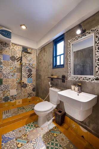 a bathroom with a white toilet and a sink at Calm House 3 Boutique hotel Hoi An in Hoi An