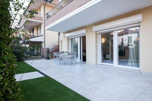 a patio with chairs and tables in a house at Casa Cate Cervia Centralissima in Cervia