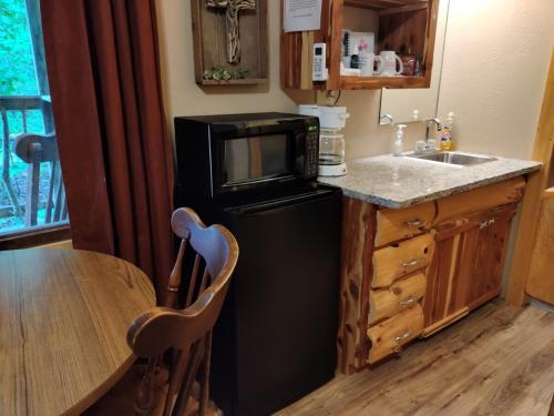 een keuken met een zwarte koelkast en een tafel bij New! Village Of Hope - All 6 Cabins in Ava