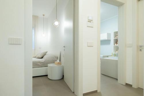 a white bedroom with a bed and a sink at Casa Cate Cervia Centralissima in Cervia