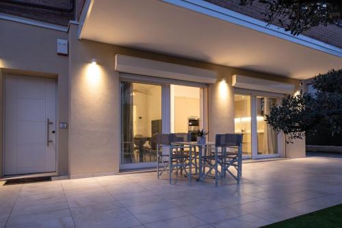 a patio with chairs and a table in front of a house at Casa Cate Cervia Centralissima in Cervia