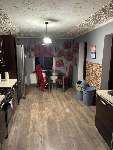 a kitchen and dining room with a table and red chairs at Apartament na spokojnej wsi in Trzebiel