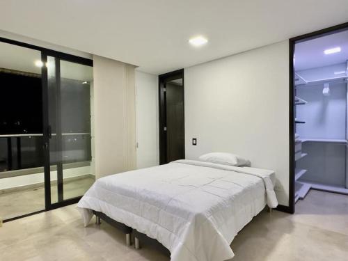 een slaapkamer met een wit bed en een groot raam bij 1401, Luxury Penthouse In El Poblado in Medellín