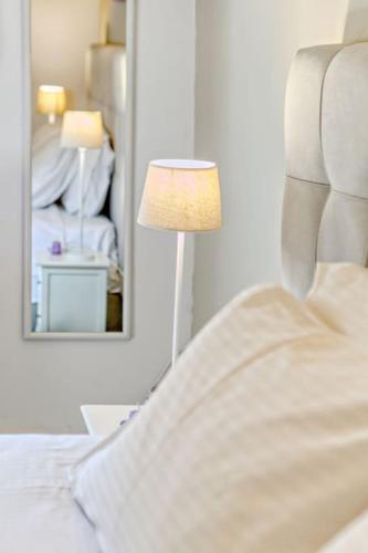 a bedroom with a bed and a mirror and a lamp at Evita's ikia seaside luxury house in Mesongi