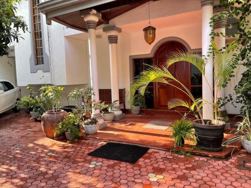 a courtyard with potted plants in front of a house at Air conditioned 3 bed home! in Nugegoda
