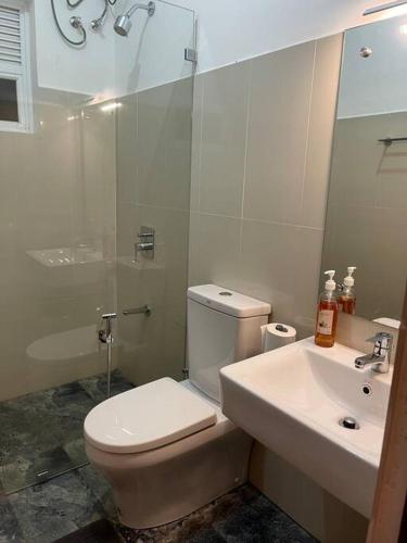 a bathroom with a toilet and a sink and a shower at Air conditioned 3 bed home! in Nugegoda