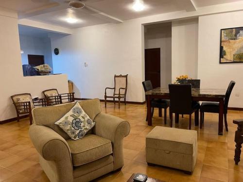 - un salon avec un canapé et une table avec des chaises dans l'établissement Air conditioned 3 bed home!, à Nugegoda