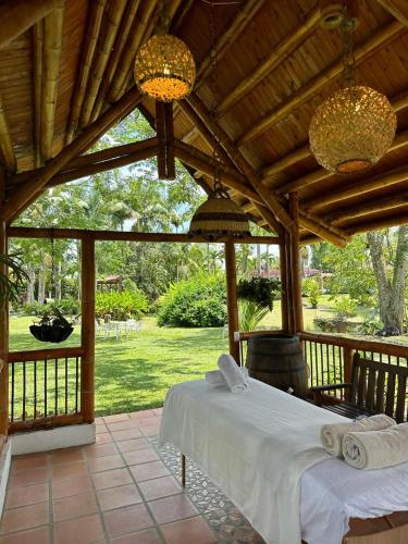 a bedroom with a white bed and a wooden ceiling at El Percal Hacienda Hotel in Montenegro