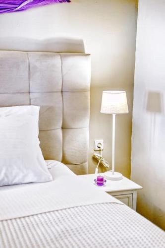 a bedroom with a white bed and a lamp on a table at Evita's ikia seaside luxury house in Mesongi