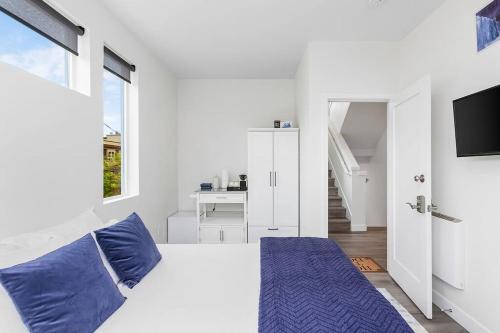 1 dormitorio blanco con 1 cama grande con almohadas azules en Martell's Sunspear Sweet Suite en Seattle