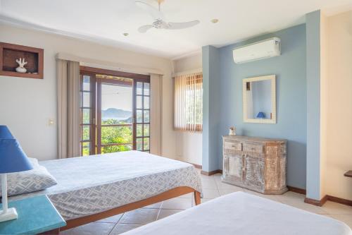 a bedroom with two beds and a window at Vista panorâmica e praia a pé. in Búzios