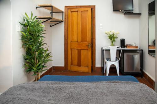 a room with a bed and a table and a door at Loddey`s Guest House - by Beach Collection in Strand