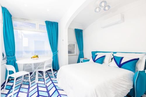 ポジターノにあるCasa Aurora Positanoの青と白のベッドルーム(テーブル、ベッド付)