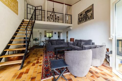 un salon avec des canapés et un escalier en colimaçon dans l'établissement Spacious semidetached house with garden & terrace, à Grimaud
