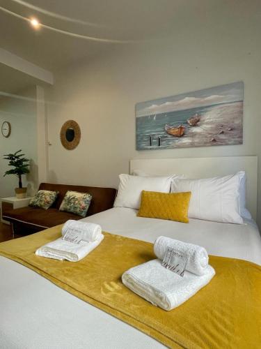 um quarto com uma cama com toalhas em CarreraHouses Brisa em Vigo