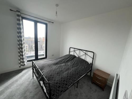 een slaapkamer met een bed en een groot raam bij A&K Inn in Bournemouth