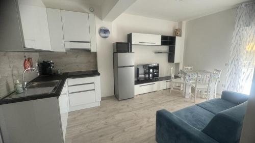a kitchen with white cabinets and a blue couch in a room at Casa vacanze Ricky in Porto Recanati