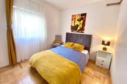 - une chambre avec un lit et une couverture jaune dans l'établissement Apartment Nera Zadar, à Zadar