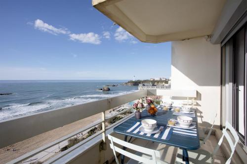 un balcon avec une table et des chaises et l'océan dans l'établissement Appartement Victoire vue mer - Welkeys, à Biarritz