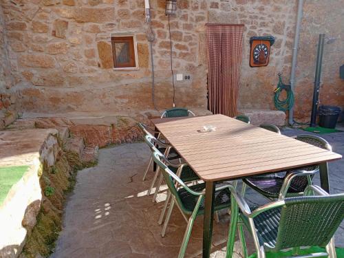 a wooden table and chairs in a stone building at El Canchal de Eladia in Valdeverdeja