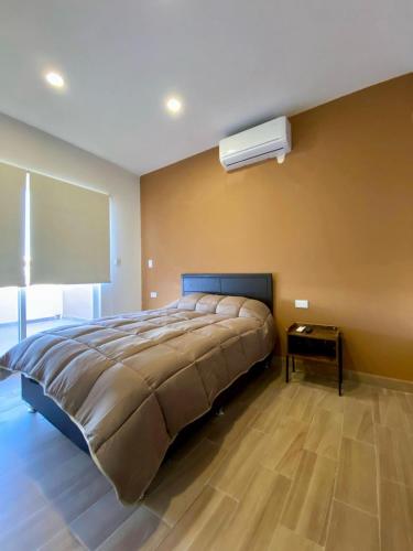 a bedroom with a large bed and a night stand at Departamento Océano in La Paz