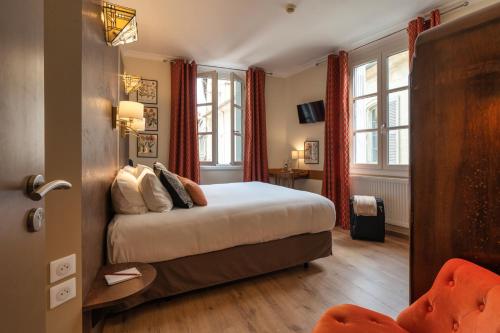 a bedroom with a bed with red curtains at Garlande Hôtel Avignon Centre in Avignon