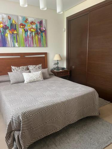 a bedroom with a bed with a wooden headboard at Alvynat Playa Mar de Pulpi in San Juan de los Terreros