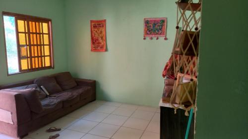 a living room with a couch and a window at Alugo casa no vale do capao in Palmeiras