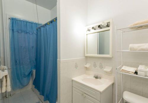 a bathroom with a sink and a blue shower curtain at Comfortable One Bedroom Apartment in New York
