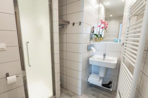 a white bathroom with a sink and a mirror at Garlande Hôtel Avignon Centre in Avignon
