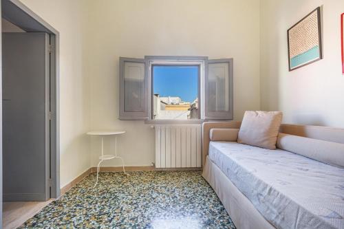 a small room with a bed and a window at Casa Kalè by BarbarHouse in Gallipoli