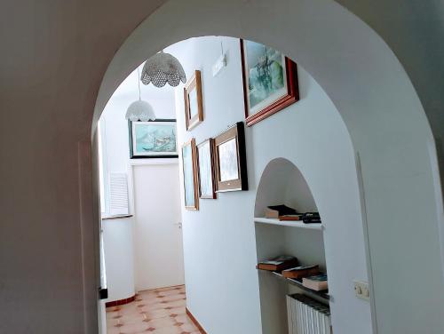 un arco en un pasillo con cuadros en la pared en La dimora di nonna Giuliana en Ostuni