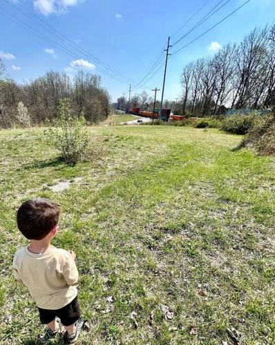 a young boy standing in a field with a frisbee at Trestle Creeks Farmhouse Fort Tiny House in Bloomington