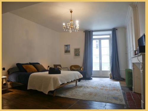 a bedroom with a bed and a chandelier at Les Suites de Bellac in Bellac