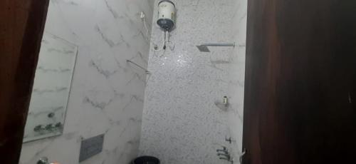 アムリトサルにあるPRABH HOMESTAYの白い大理石の壁のバスルーム(シャワー付)