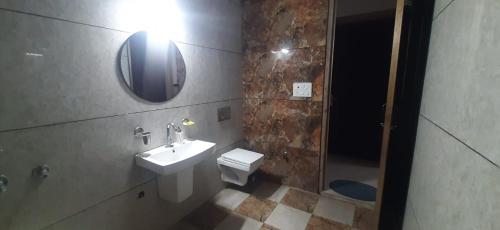 a bathroom with a sink and a toilet and a mirror at PRABH HOMESTAY in Amritsar