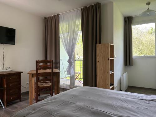 une chambre avec un lit, un bureau et une fenêtre dans l'établissement Appartement normandie avec piscine et jardin, à Équemauville