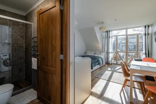 1 dormitorio con 1 cama y baño con ducha. en SOLEMAR romantic studio with lagoon View!, en Pervalka