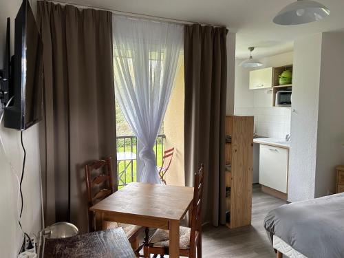 Cette chambre dispose d'une table à manger et d'une fenêtre. dans l'établissement Appartement normandie avec piscine et jardin, à Équemauville