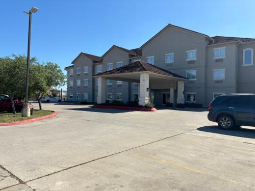 a car parked in a parking lot in front of a building at Deluxe 6 Inn & Suites in Brownsville