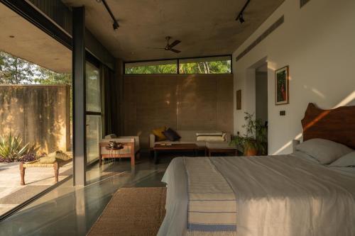 1 dormitorio con 1 cama y sala de estar en Jaadooghar Stays, Earth Friendly Stay, Chandigarh, en Chandīgarh