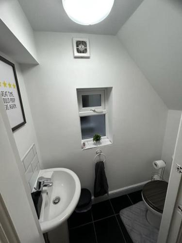 ein kleines Bad mit einem Waschbecken und einem WC in der Unterkunft Lovely 5BR Home in Manchester. Close to the City in Manchester