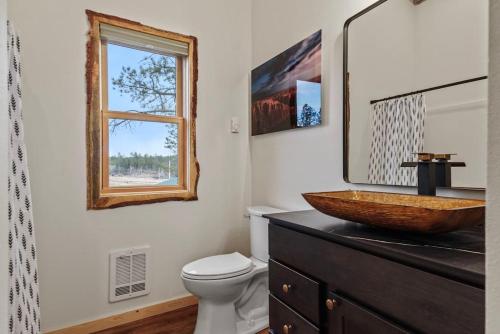 a bathroom with a sink and a toilet and a window at Hottub Haven BHBungalows #9 in Custer