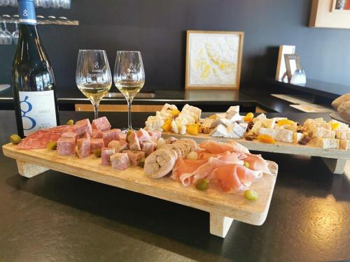 Les Suites Gueguen في شابلي: طبقين من الطعام وكؤوس النبيذ على الطاولة
