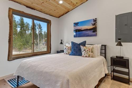 Un dormitorio con una cama grande y una ventana en Hottub Haven BHBungalows #9, en Custer