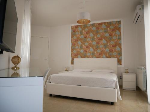 a bedroom with a bed with a painting on the wall at Casa Vacanze Le Tre Scimmiette Chic in Paterno