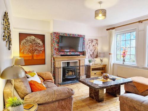 a living room with a couch and a fireplace at Blacksmiths Cottage, Bosham in Bosham