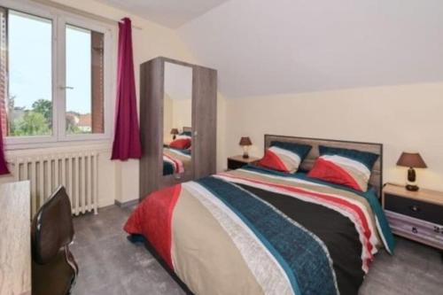 a bedroom with a bed and a mirror at Maison agréable et spacieuse dans le Loiret in Sully-sur-Loire