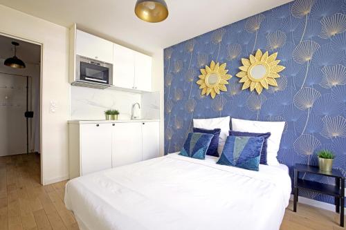 - une chambre dotée d'un lit avec un mur bleu et jaune dans l'établissement Balcony studio near Buttes Chaumont, à Paris